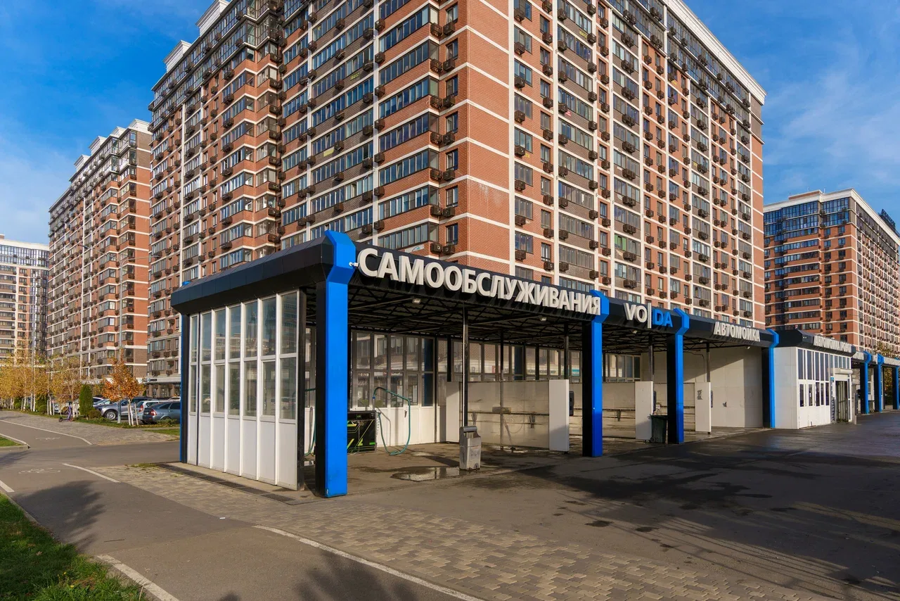 Автомойка самообслуживания VODA при жилом комплексе: синий навес с вывеской «Самообслуживания»